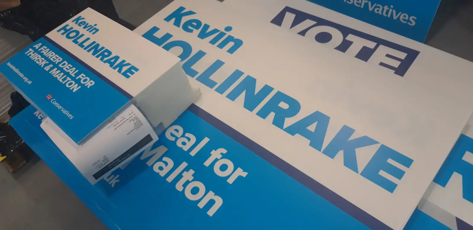 How do political candidates use election signs and other campaign materials to influence voters