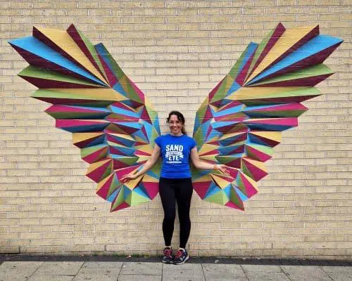 Photo of angel wings made out of wall stickers with a lady stood in the middle to complete the image