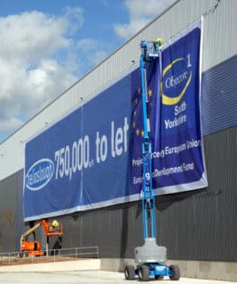 large format promotional banner being hung
